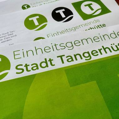 Das neue Logo der Einheitsgemeinde zusammen mit dem Schriftzug auf diversen Dokumenten.